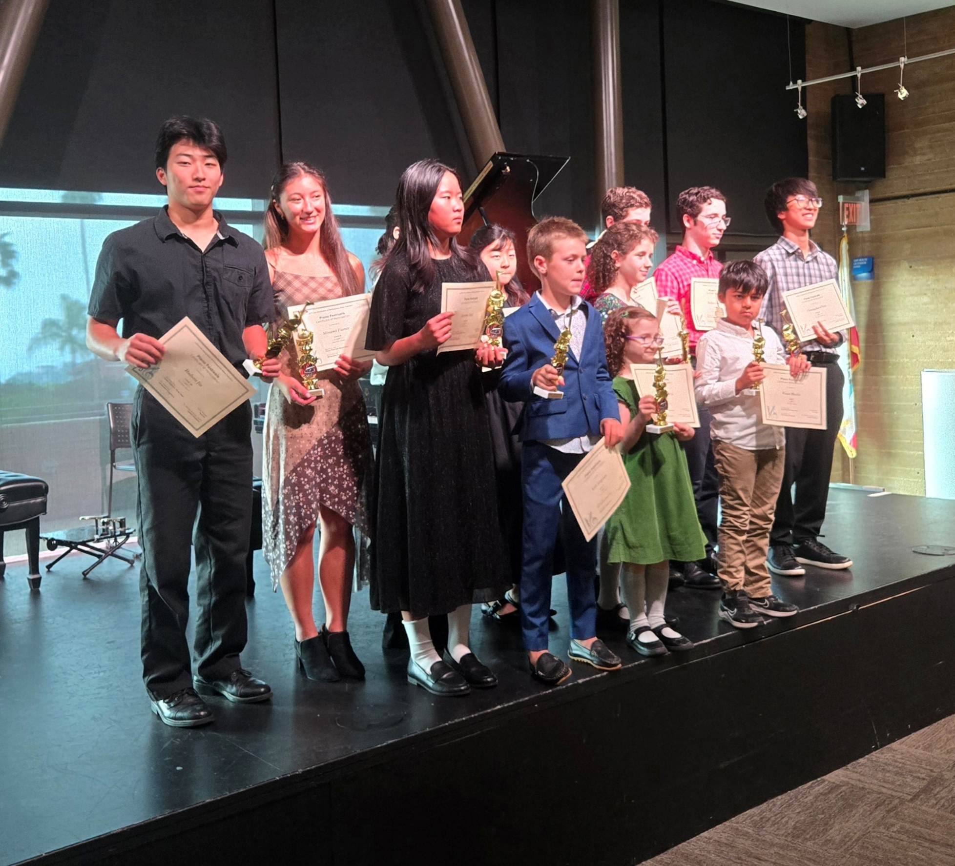 A group of people holding papers on a stage

AI-generated content may be incorrect.