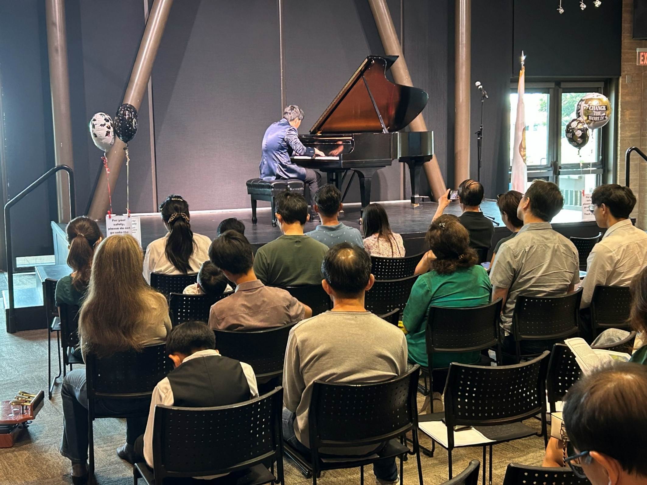 A group of people sitting in chairs watching a person play a piano

AI-generated content may be incorrect.